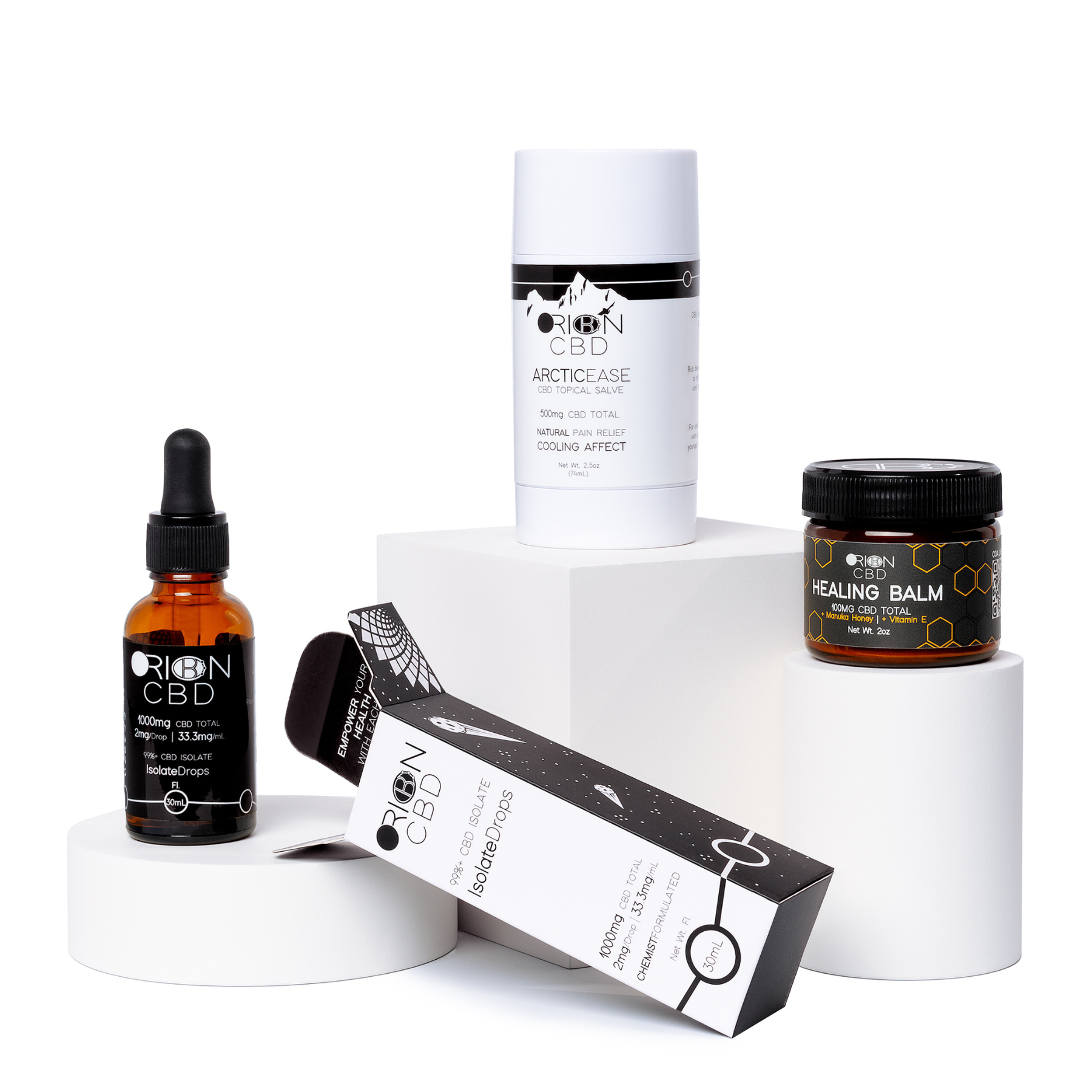 Orion CBD Recovery Bundle featuring Isolate Drops, Healing Balm, and Pain Relief Salve Stick on white blocks with the isolate drops box laying on its side
